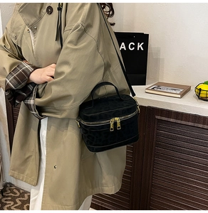 Detail der Crossbody-Tasche aus Wildleder mit Leopardenmuster und goldenen Reißverschlüssen