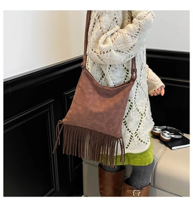 Detailed view of a brown tassel shoulder bag with bohemian fringe and soft suede texture
