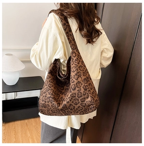 Side view of large leopard print hobo tote bag with suede texture on female model