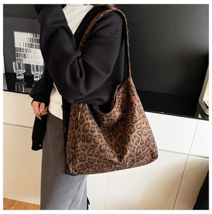 Leopard print tote bag shown on shoulder in a stylish minimalist setting