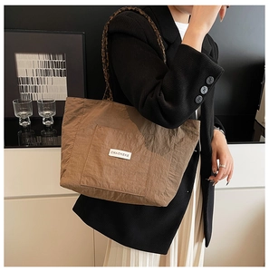 Détail d'un grand sac cabas en nylon avec bandoulière léopard et étiquette blanche