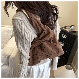 Detailed view of brown corduroy shoulder bag with oversized bow and heart prints