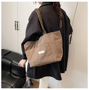 Gros plan sur un sac cabas marron avec anse léopard et texture gaufrée moderne