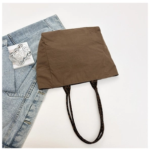 Gros plan du sac cabas marron café avec anses léopard et texture en toile douce