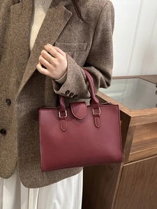 Classic burgundy leather tote bag for women featuring round handles and gold hardware