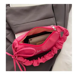 Interior view of rose pink hobo bag with zipper opening and bow embroidery detail