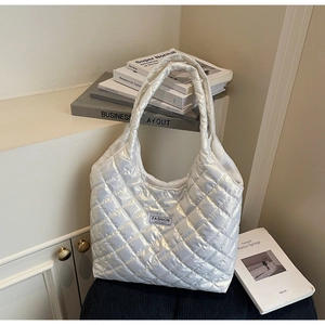 Detail view of the white quilted puffer tote bag with Fashion Instinct square label