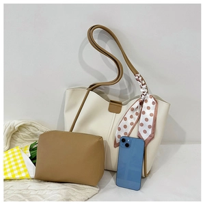 Detail view of cream tote bag with brown handles, polka dot scarf, and matching pouch