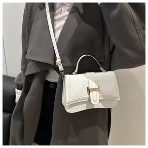 Side view of model wearing a white quilted leather shoulder bag with golden buckle