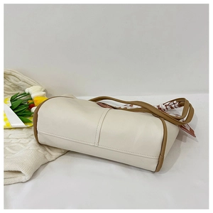 Detail of Boston tote bag in cream faux leather with brown trim and polka dot scarf