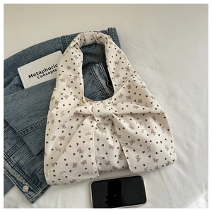 Detail of cream corduroy tote bag with large bow and printed heart patterns