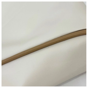 Close-up of minimalist tote bag showing premium lychee grain leather and contrast stitching
