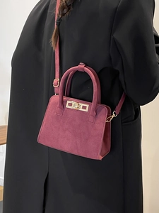 Elegant burgundy suede handbag for women featuring a gold metallic twist lock