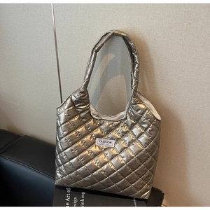 Detail of champagne gold quilted tote bag with rhombus pattern and fashion label