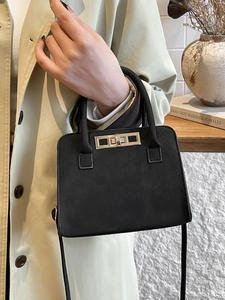 Vintage black matte Kelly bag with gold hardware and shoulder strap in casual setting