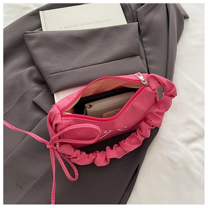 Detail view of pink flap bag showing interior space and matching small coin purse inside