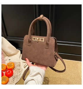 Close-up of brown suede kelly bag showing matte texture and gold-tone metal twist lock