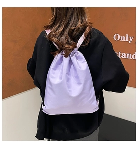 Rear view of a light purple drawstring backpack showing shoulder fit and large capacity