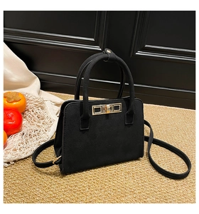 Detail of minimalist black frosted suede tote with a modern gold rectangular twist lock