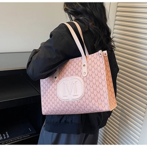 Detailansicht der rosa-weißen Tragetasche mit M-Monogramm und geprägtem Rundlogo