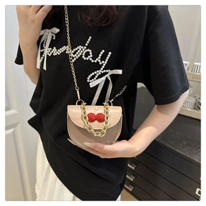 Detail of light pink mini saddle bag with cherry hardware and fine gold chain strap