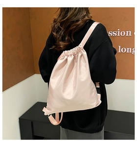 Detail of light pink drawstring nylon bucket bag with lightweight adjustable straps