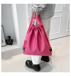 Detailed view of light pink drawstring backpack bucket bag with soft nylon texture