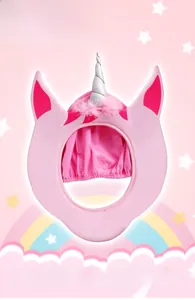 Close-up of pink unicorn headgear with silver spiral horn and soft feather details