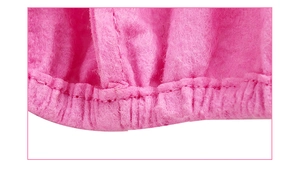 Macro shot of the pink plush fabric texture and elastic stitching on the unicorn hat