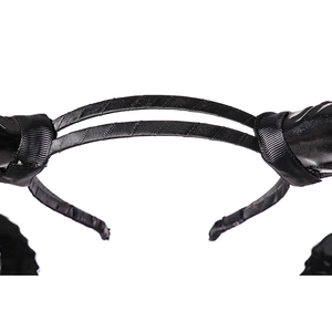 Détail de serre-tête noir en gros-grain avec accents de cuir brillant pour accessoires