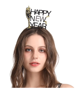 Close-up of Happy New Year headband with black glitter letters and golden champagne glass