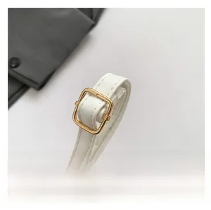 Detail of white quilted handbag strap with adjustable golden metal buckle and stitching