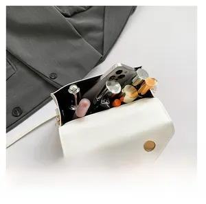 Macro shot of the white envelope bag interior showing large capacity for phone and cosmetics
