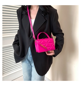 Hot pink quilted small handbag with gold metal bar detail and adjustable crossbody strap