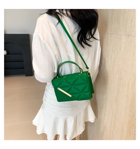 Green crossbody bag with geometric triangle texture and gold metal bar detail