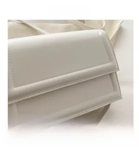 Close-up of white leather shoulder bag featuring exquisite stitching and flip-top design