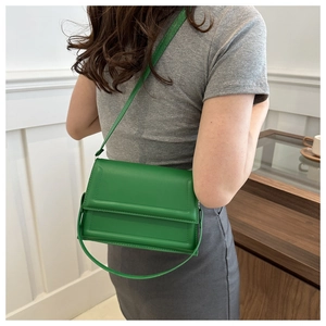 Dettaglio della borsa a tracolla verde minimalista con cuciture e doppi spallacci