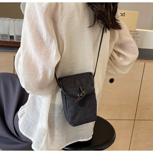 Detail of vintage gray canvas phone bag with classic toggle button and leather strap