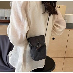 Dettaglio della borsa a tracolla in denim vintage con fibbia in corno e cinturino