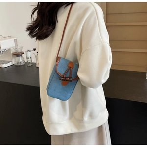 Retro denim crossbody phone bag featuring a vintage toggle closure and brown leather straps
