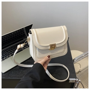Détail du sac bandoulière carré crème minimaliste avec fermoir en métal doré de qualité