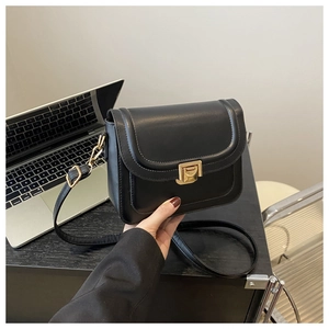 Détail du petit sac bandoulière noir en similicuir avec fermoir poussoir doré et rabat