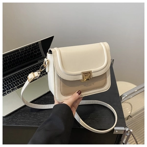 Détail du sac bandoulière bicolore crème et marron clair avec fermoir en métal doré
