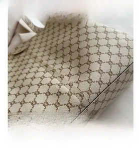 Dettaglio del motivo Triomphe vintage su borsa in pelle beige con cuciture rifinite