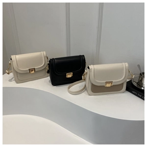 Trois sacs selle minimalistes en crème et noir avec boucles dorées sur des escaliers