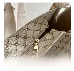 Dettaglio della cerniera dorata e della trama in pelle monogramma della borsa tote