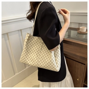 Vista laterale della grande borsa tote vintage off-white portata a spalla per ufficio