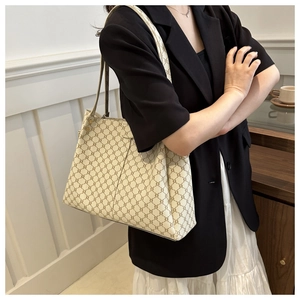Dettaglio borsa tote monogram classica in tela beige con motivo vintage sulla spalla