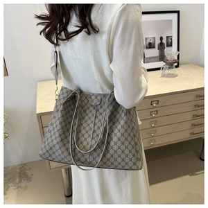 Dettaglio della grande borsa tote con motivo monogramma retrò e tracolla rimovibile