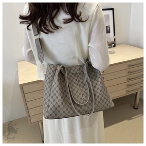 Foto lifestyle di una capiente borsa tote con motivo geometrico e ampia tracolla in tessuto